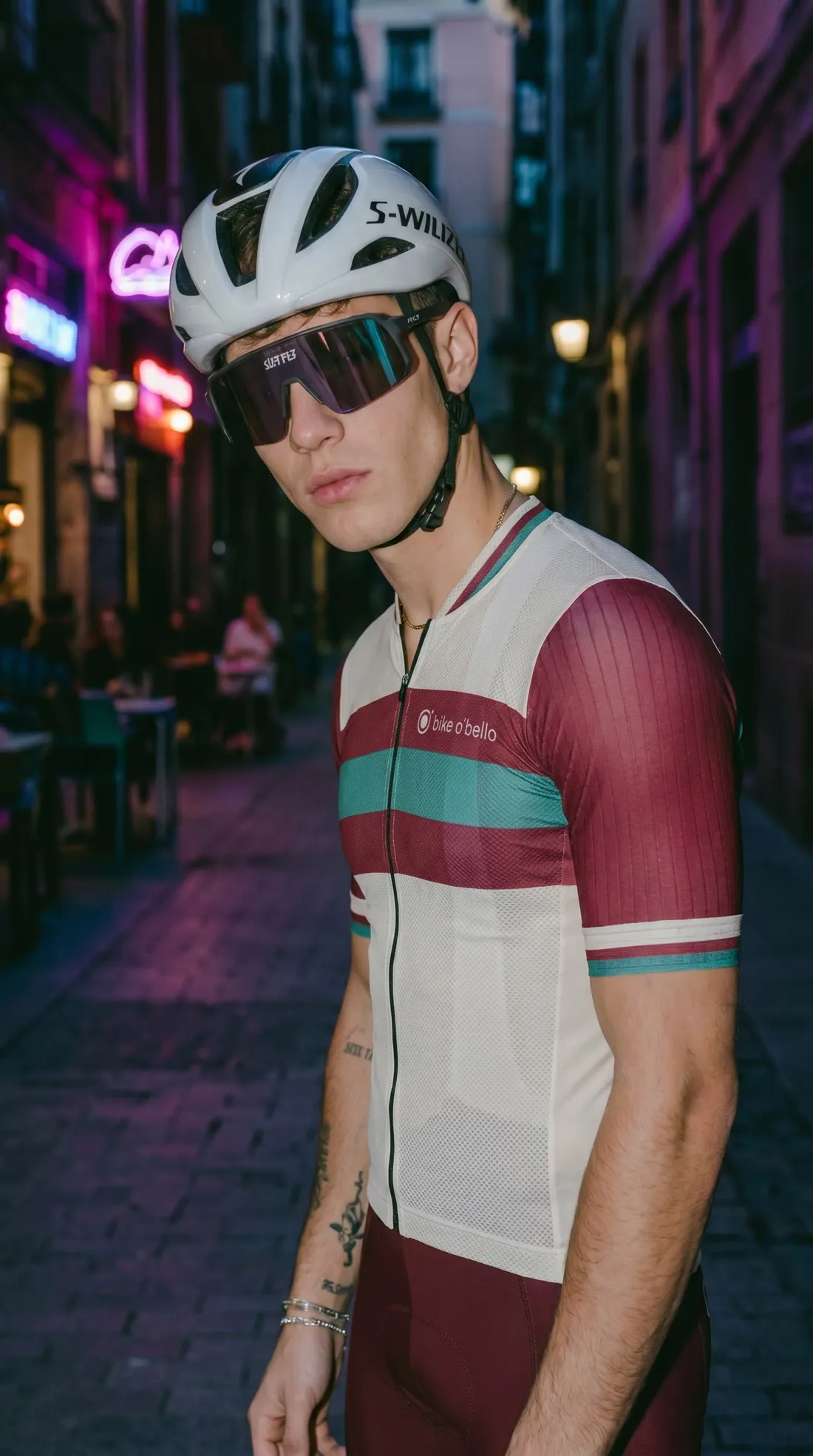Retrato nocturno en una calle con neones, casco puesto.